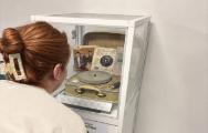 Lady looking in museum box at record player